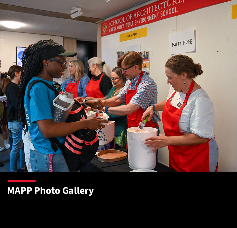 People in red aprons scooping ice cream