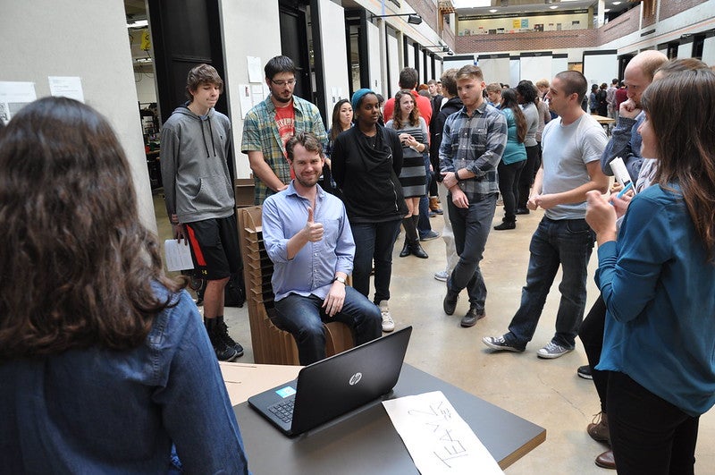 student tests out carboard chair