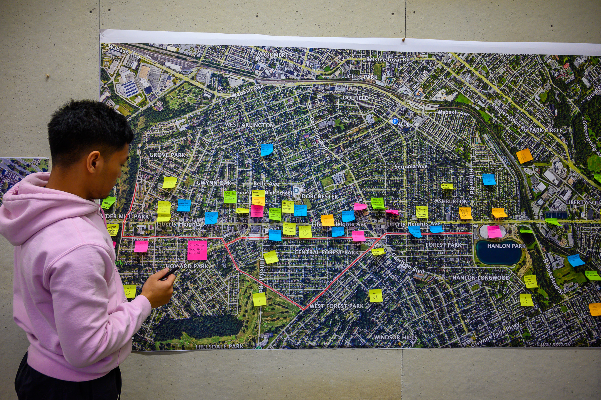 A large sitemap with sticky notes and a student looking at it