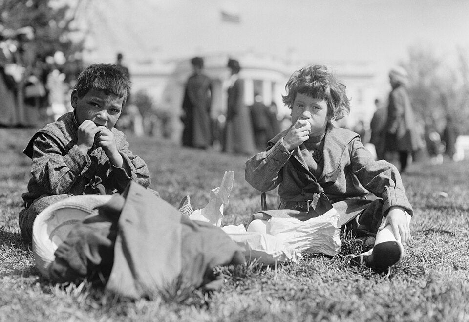 Two boys eating eggs during White House easter egg rolls