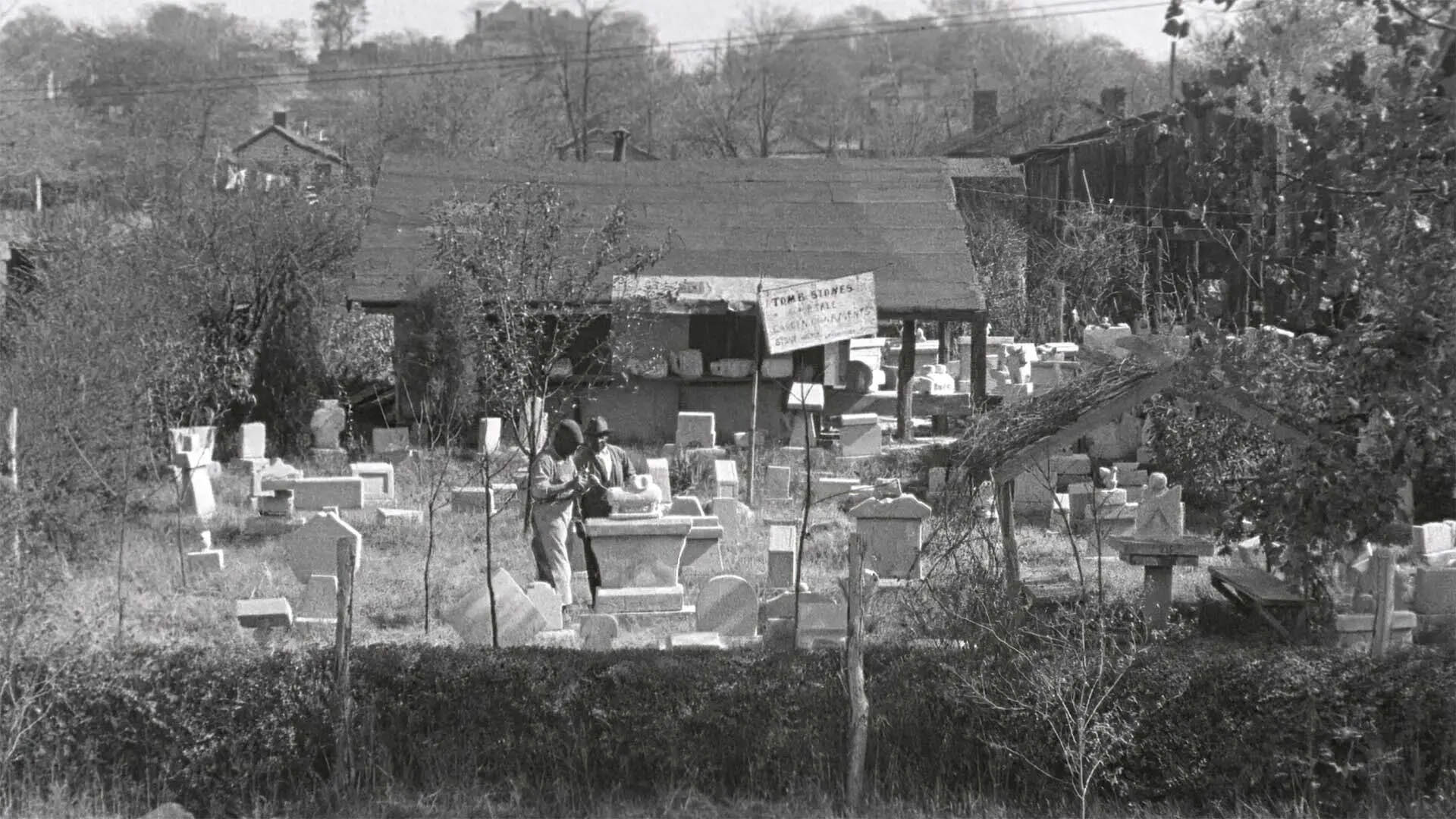 Black and white photo of people at a cemetery