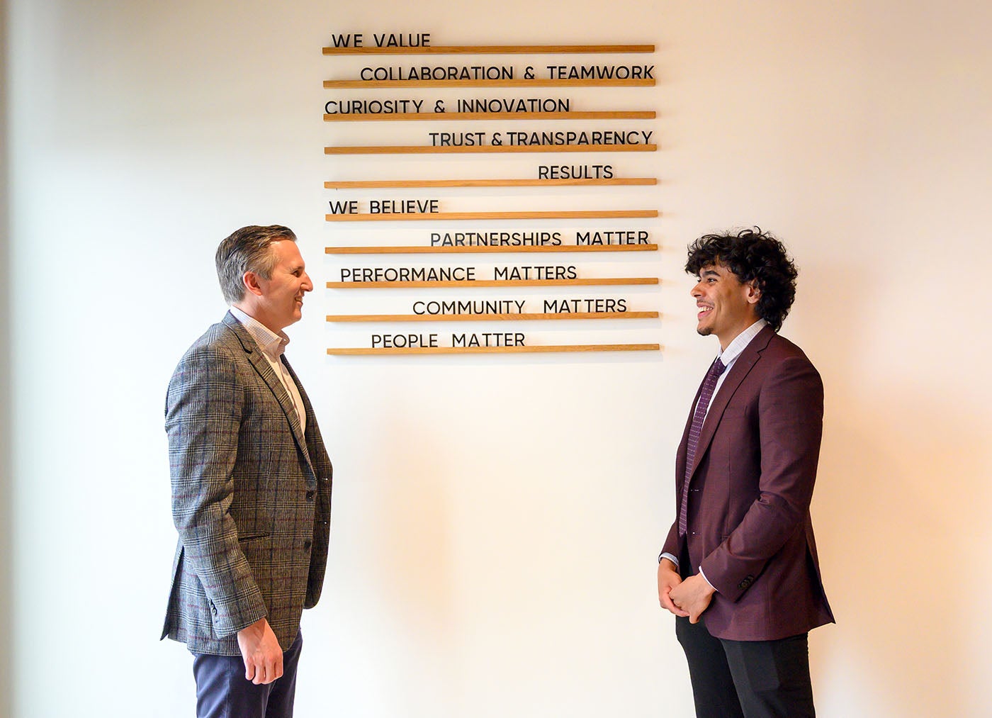 Eric Walter and Elliot Genus in front of a wall that lists company values