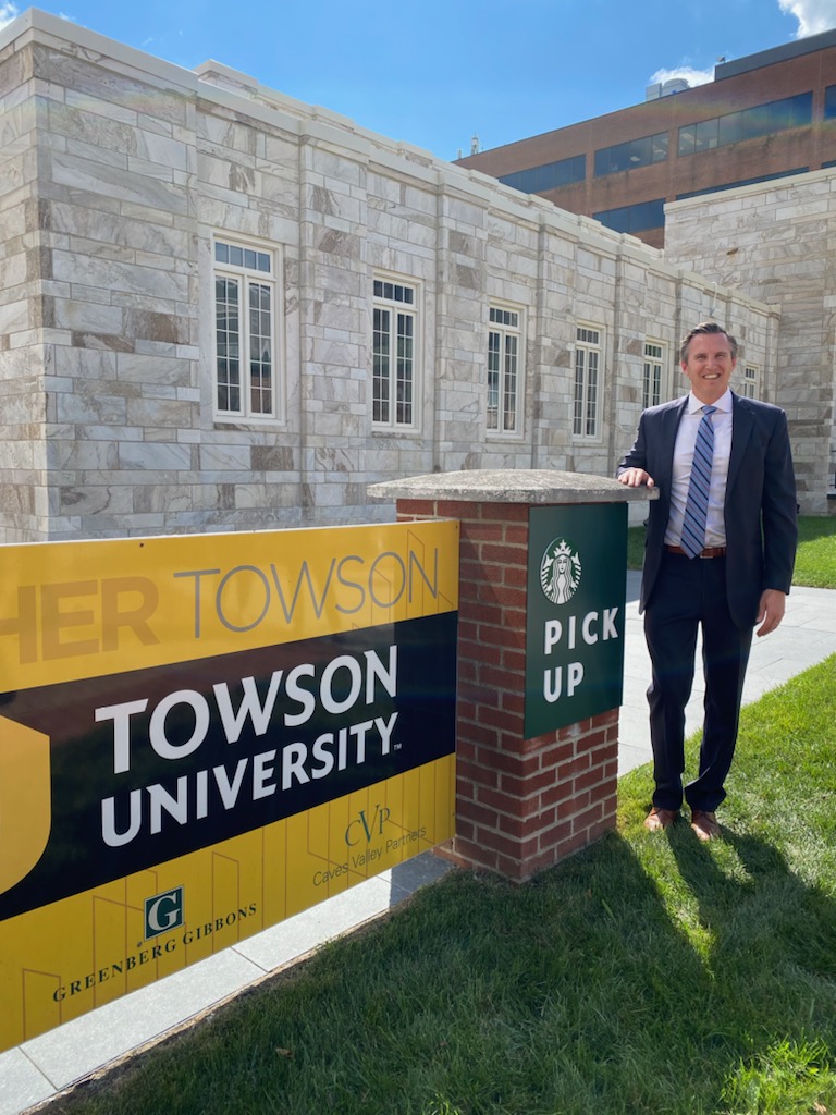 Eric Walter by Towson Row sign.