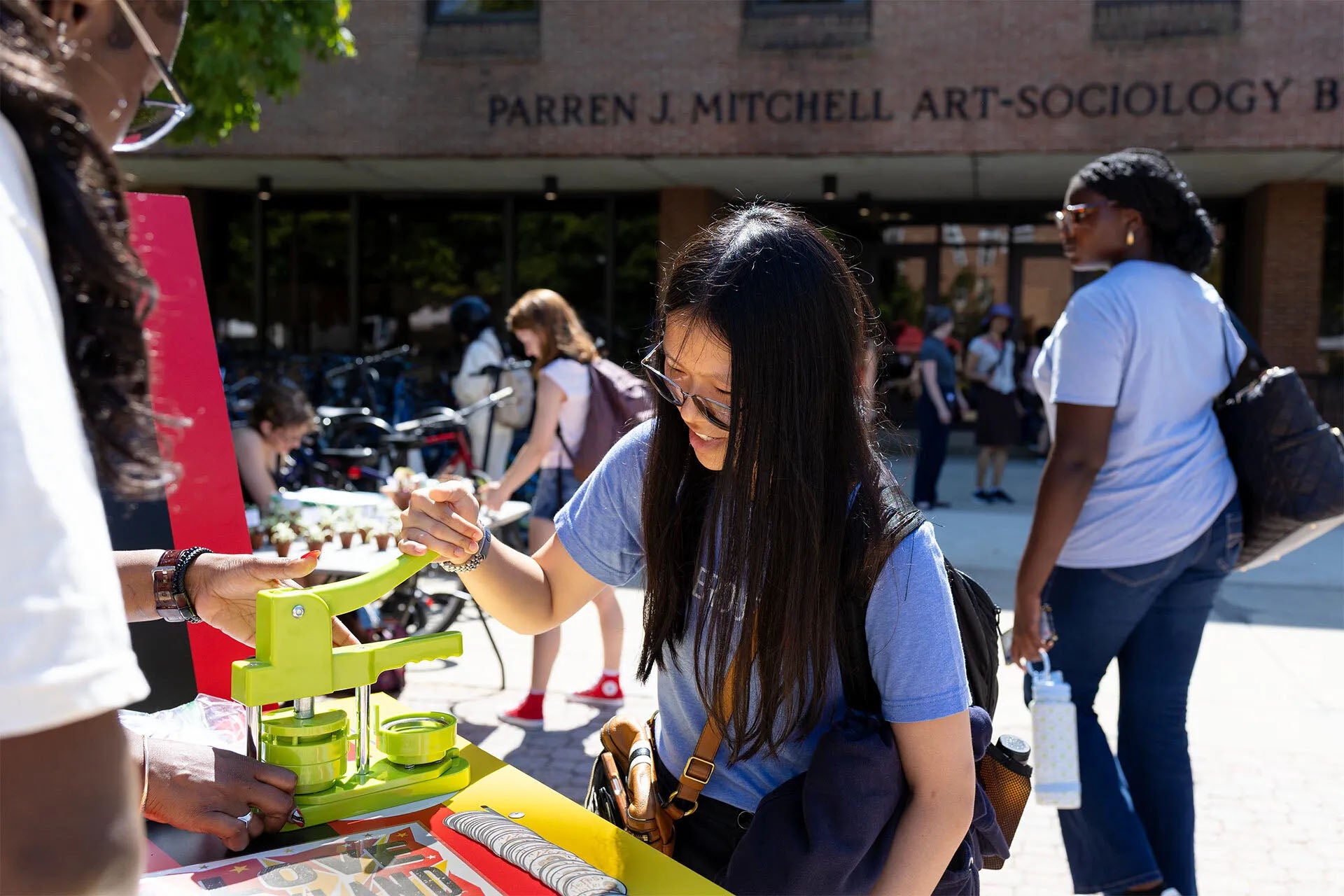 A student making a button at the the TerpsVote bicycle