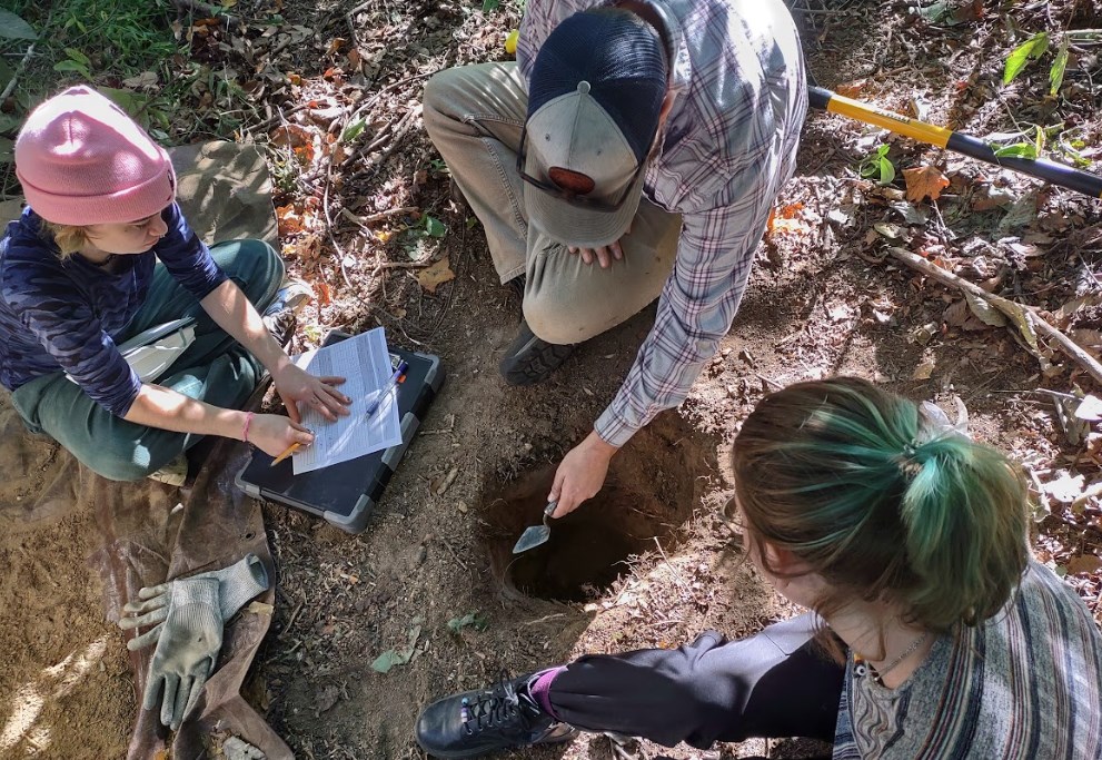 Faculty and students excavating in the dirt.