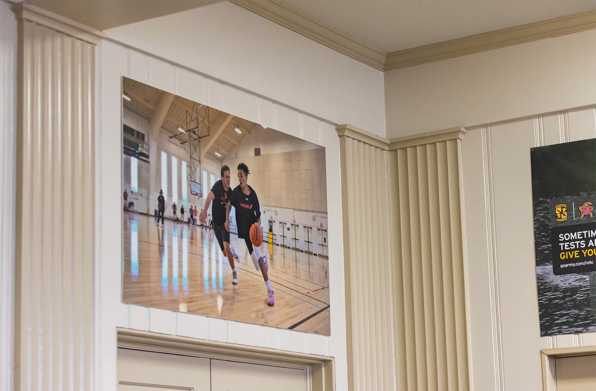 Picture frame of people playing basketball, amongst molding on walls