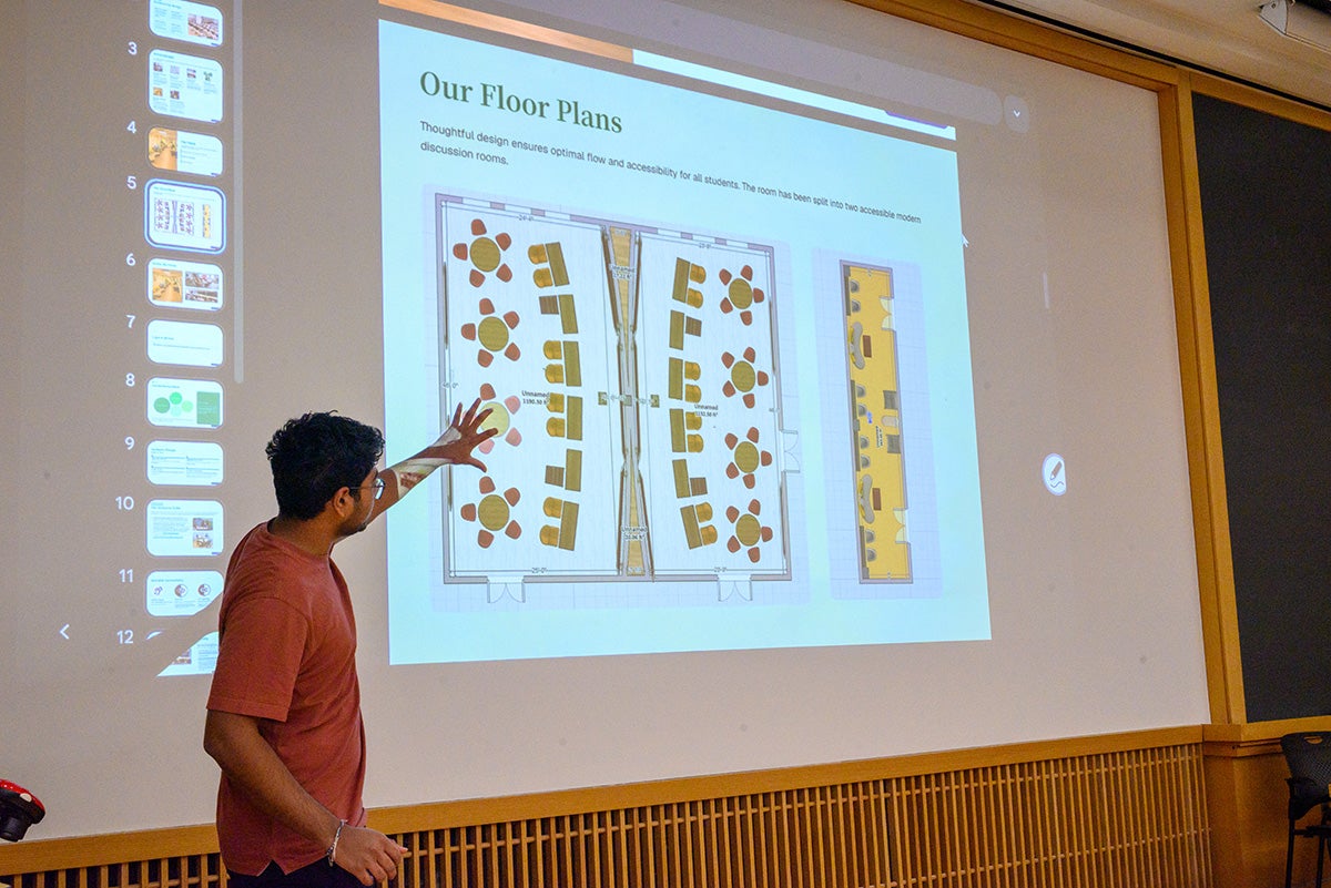 A student gesturing towards a slide showcasing floor plans