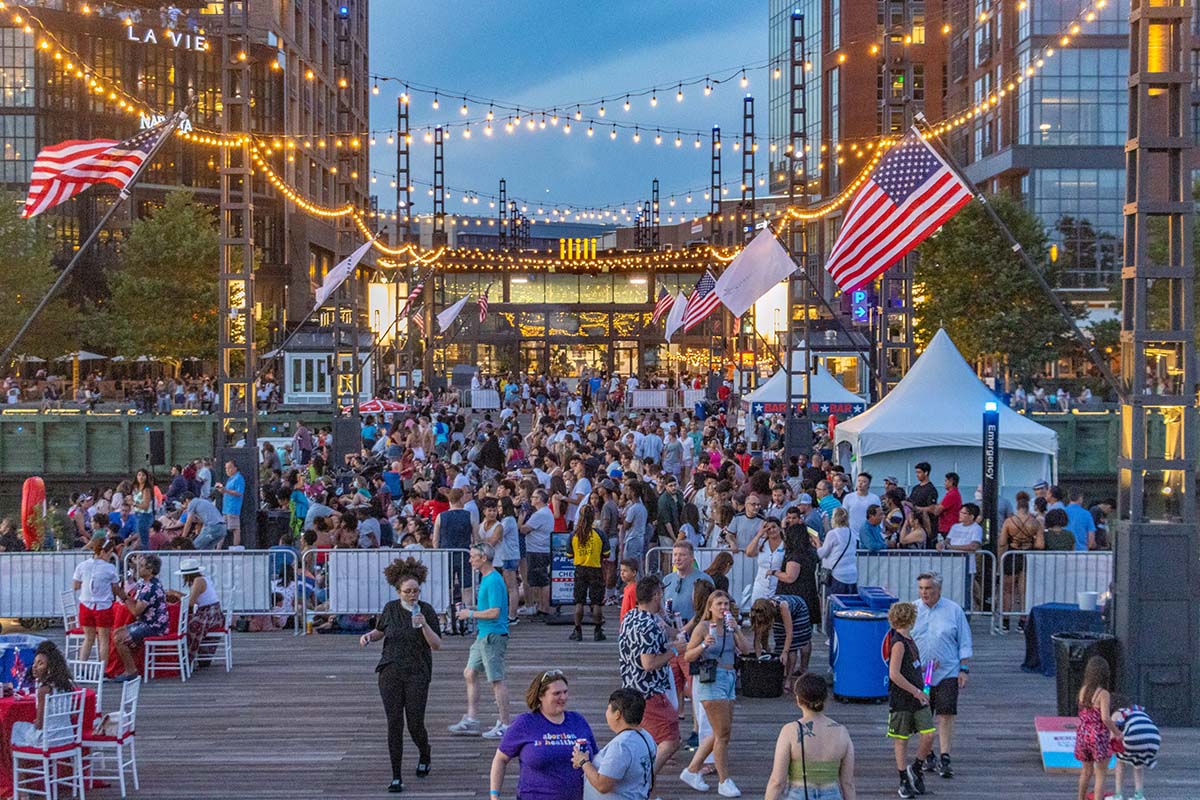 A busy pedestrian street at the Wharf in DC during nighttime.