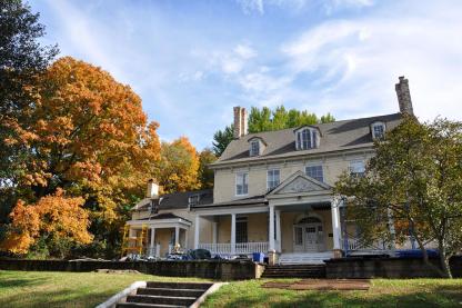 Bostwick House with fall trees and a bright blue sky