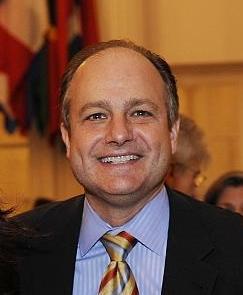 A man in business attire smiling for a photo 