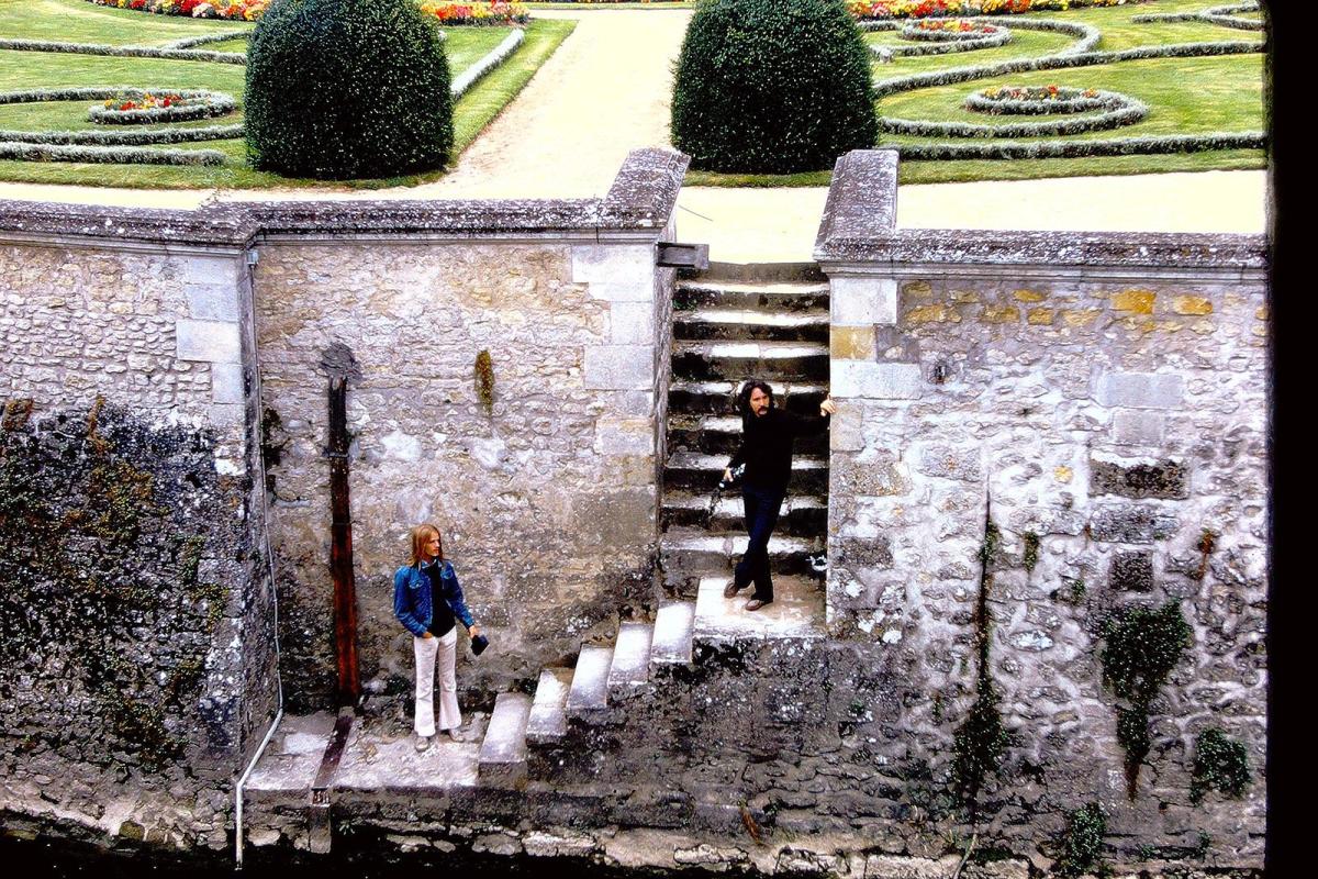 Students on stone stairway, green gardens are behind them