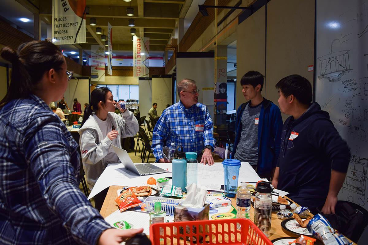 Students gathered around their mentor during Placehack