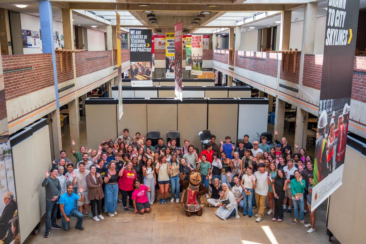 Group shot of students, faculty and staff in the Great Space with Testudo.