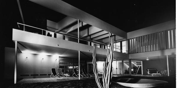 Black and white photo of Varsano Villa in Casablanca. A cactus in in the foreground and reclining chairs are on the patio.
