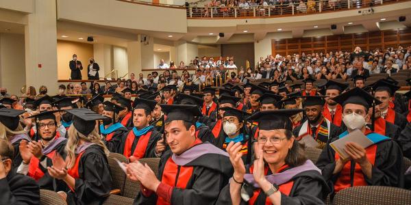 Spring 2022 Commencement, graduating students in audience clapping.