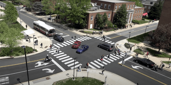 University of Maryland stadium and regents intersection. Cars, bikers and people are crossing.