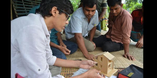 Khondakar Kabir showing an architecture model to people