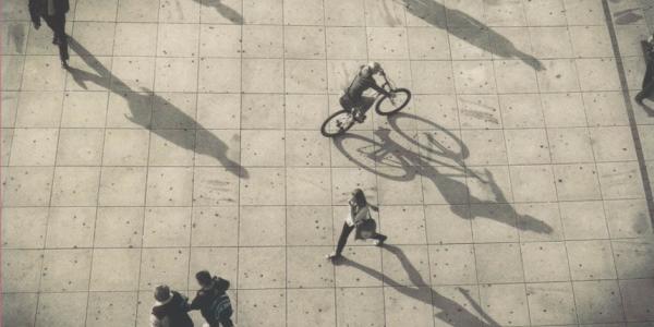 Top view of people walking and biking, showing long shadows