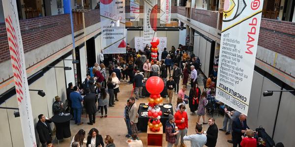 People gathered for a graduate reception in the Great Space with balloons and colorful banners