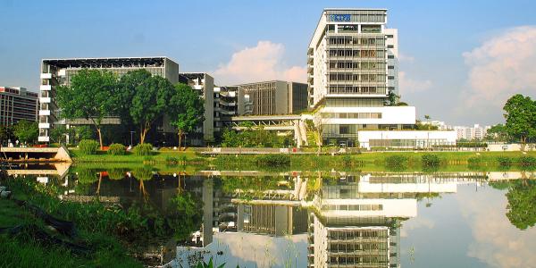 Tall building by the water and reflected in the pond