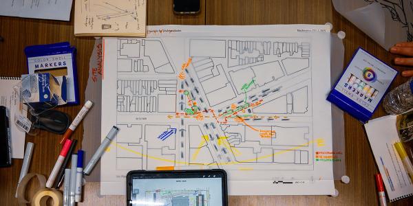 Drawings on a site plan along with markers, an iPad and scotch tape