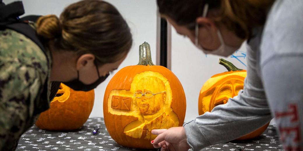 Students looking at carved pumpkin