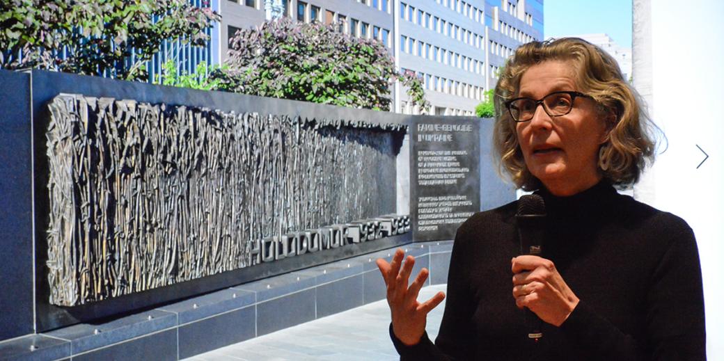 Larysa Kurylas presenting the Holodomor Memorial, which is pictured in the screen behind her.