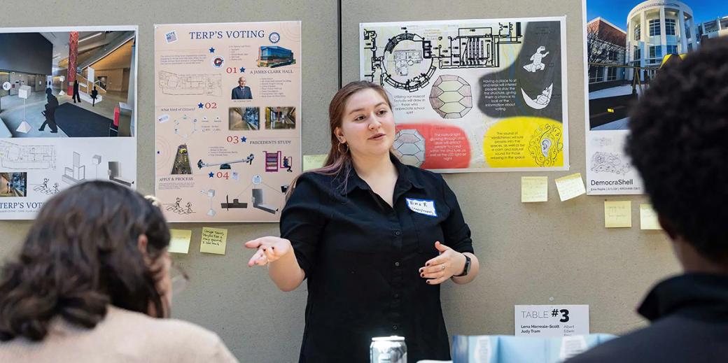 Student presenting with Terp's Voting posters behind her 