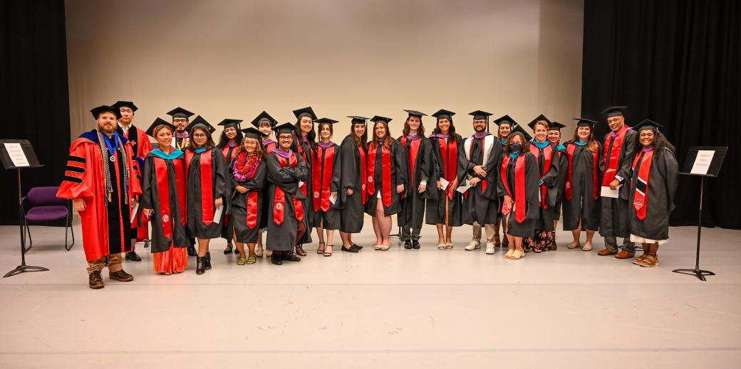 Spring 2024 Graduate Commencement Class posing in gowns and regalia