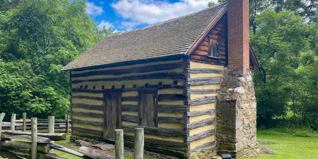 Oakle Cabin made of wooden logs and a stone and brick chimney.