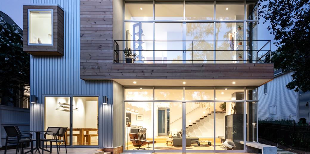 A grid-structured home with large windows, pictured at dusk.