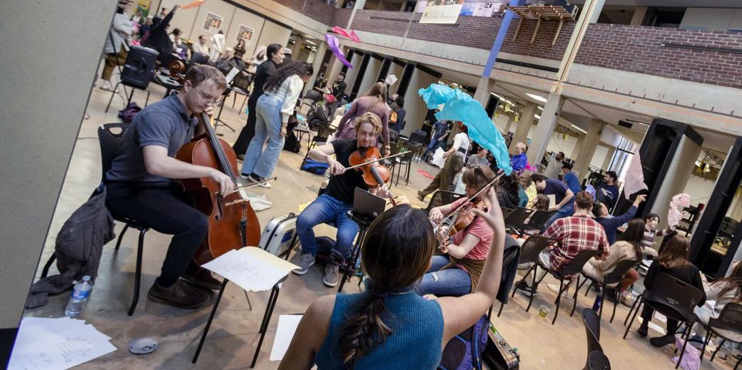 People playing instruments and throwing colorful paper in the air.