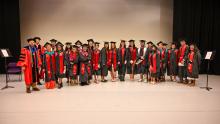 Spring 2024 Graduate Commencement Class posing in gowns and regalia