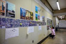 A student posting sticky notes on a project pinup