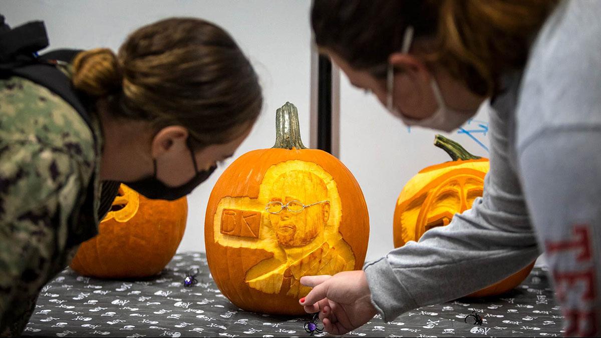 Students looking at carved pumpkin