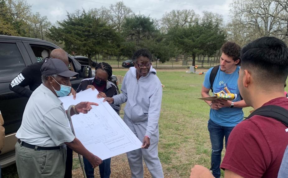 Andrea Roberts holding cemetery map with Doc Williams and undergraduate students.
