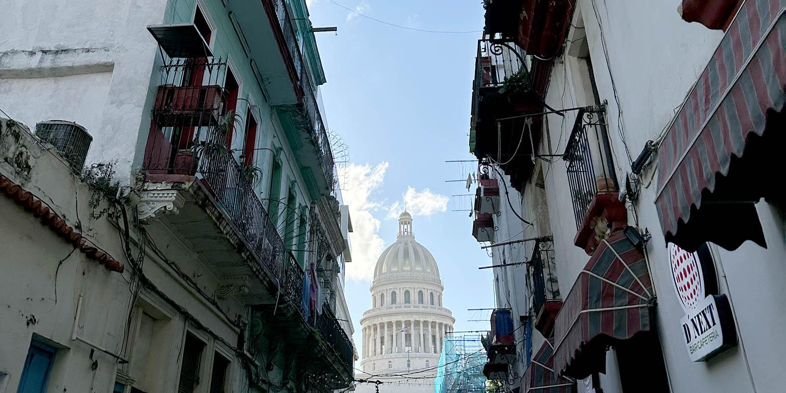 In the foreground building are falling apart and the Cuban capitol is in in the background