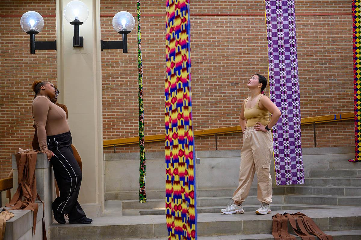 The women looking up at fabric hanging from a mezzanine