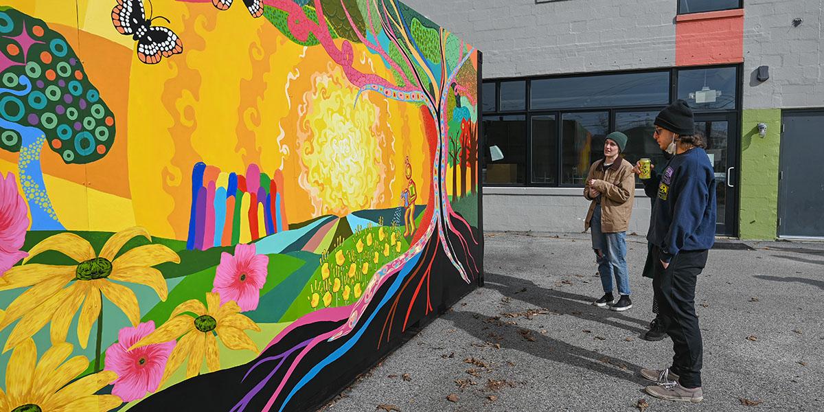 Students looking at a vibrant mural
