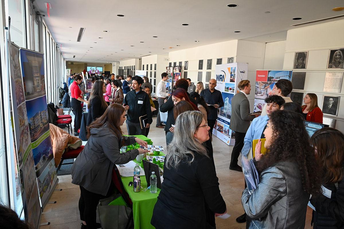 A bustling Career & Internship Fair with people networking. 