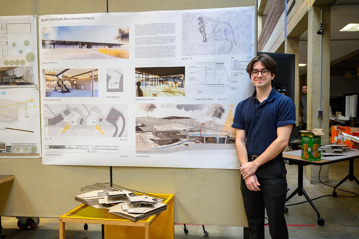 Student standing in front of his project pinup