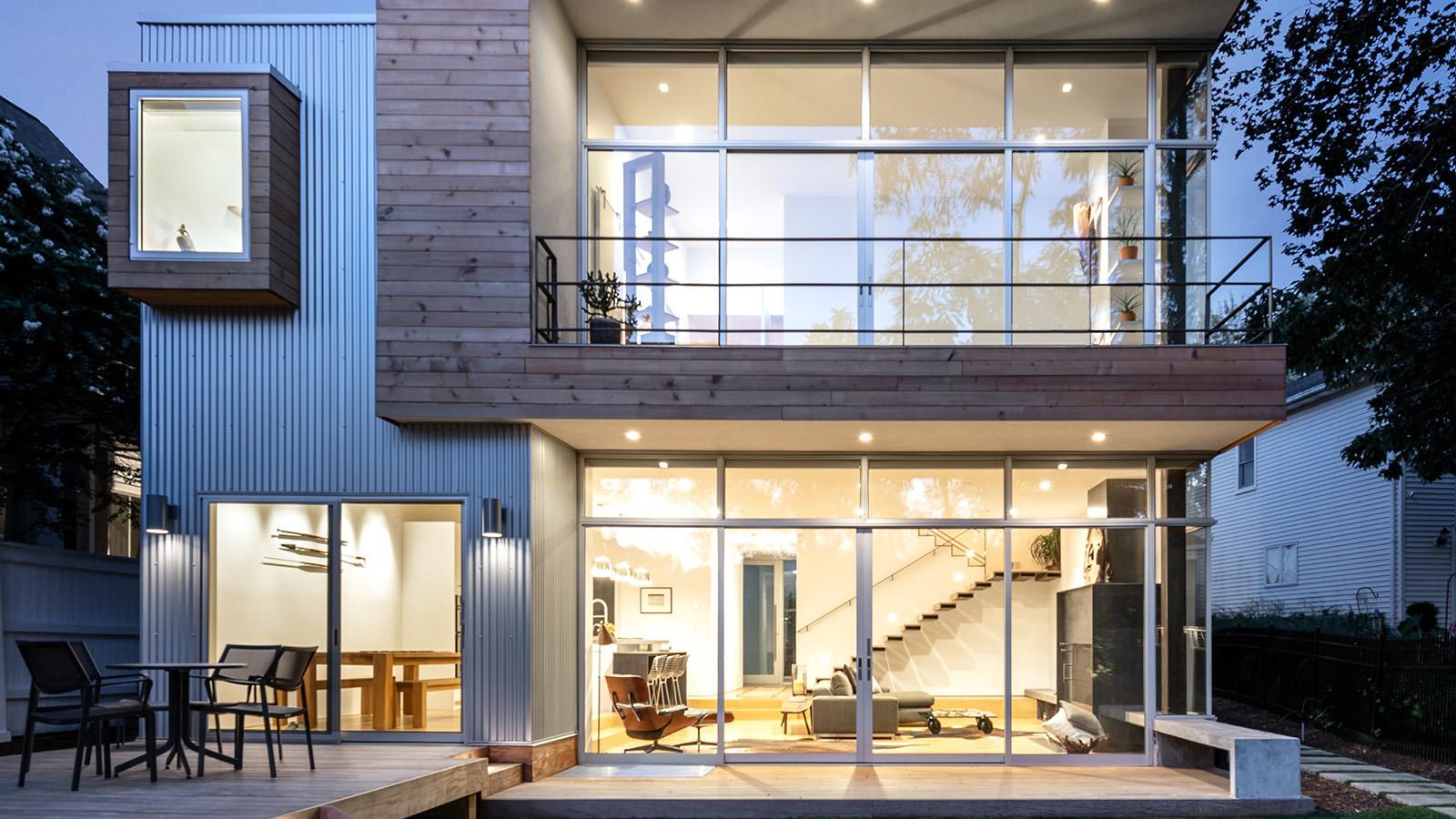 A grid-structured home with large windows, pictured at dusk.