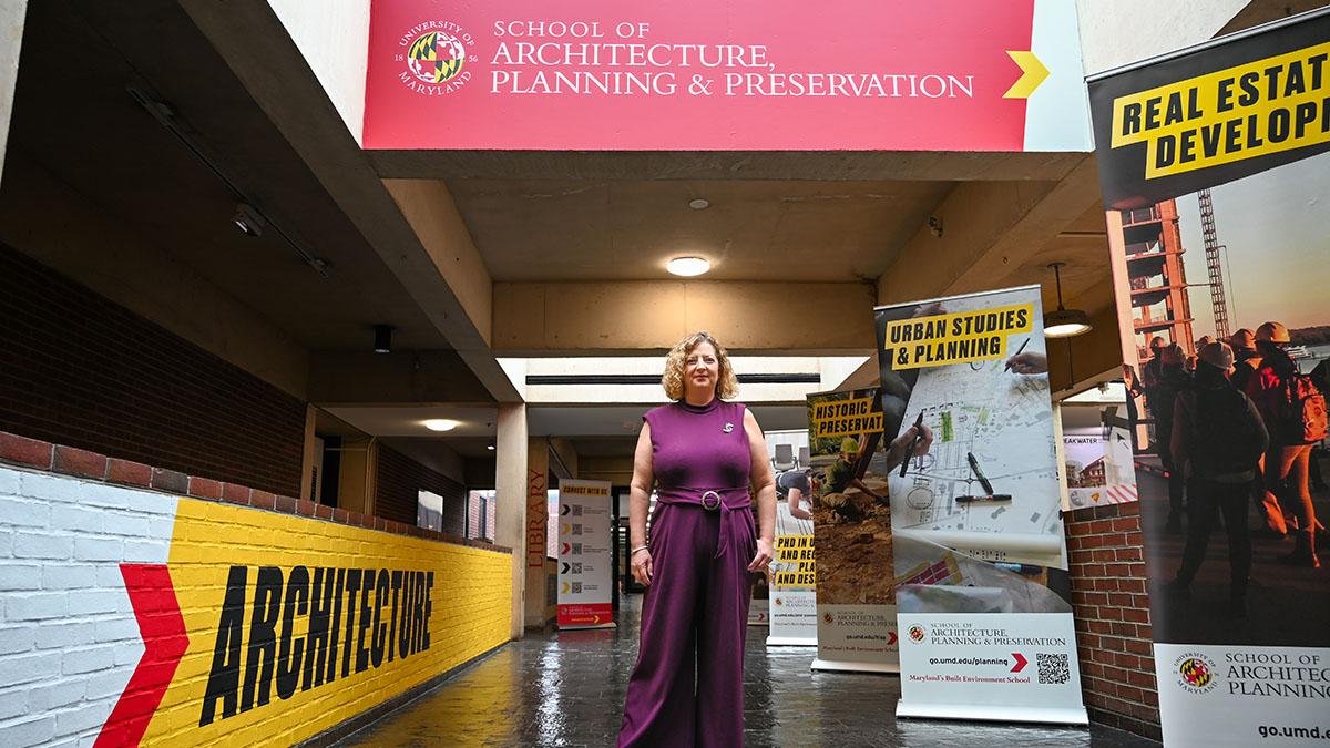 Dean Dawn Jourdan standing in the Architecture Building with posters and signage around her.