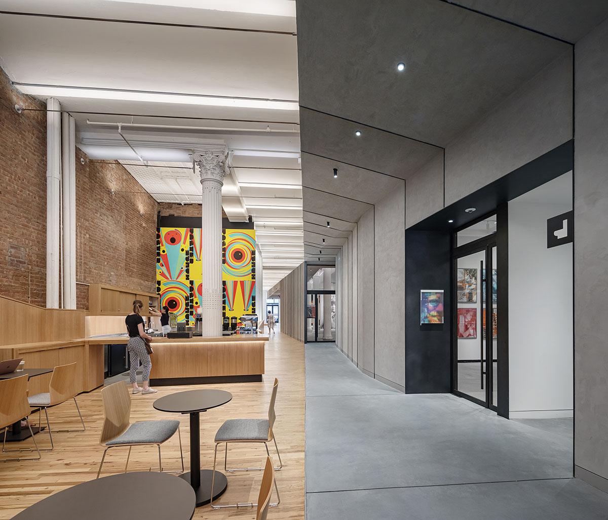 Split image of the interior of a building with a colorful mural, brick wall and wooden floor versus a concrete grey and black interior.