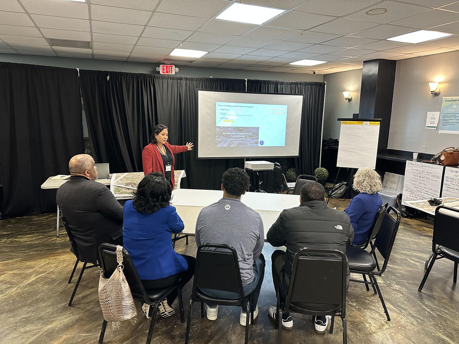 Cathy Morrison presenting to a group of people around the table.