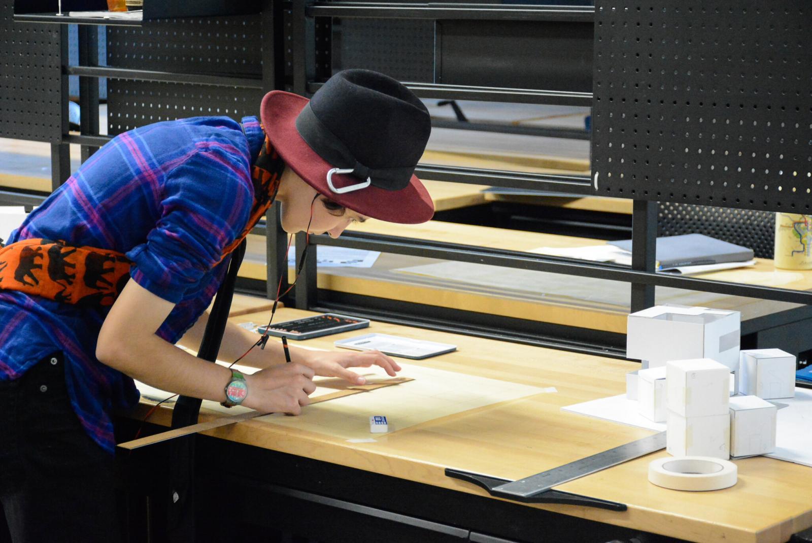 A high school student measuring at a work station