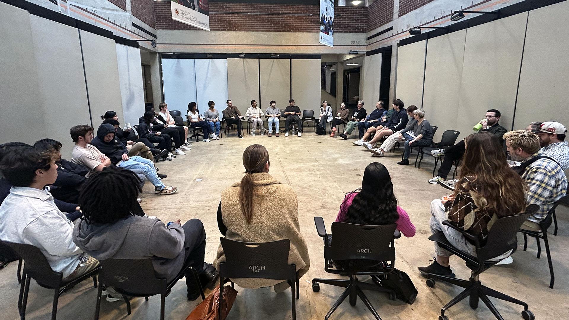 People sitting in a circle in chairs in the Architecture Building's Great Space