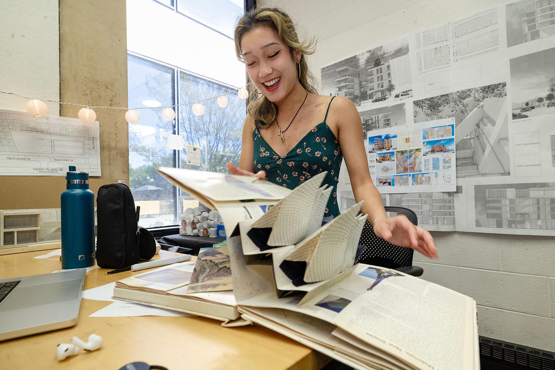 Student at her studio desk opening a pop-up book
