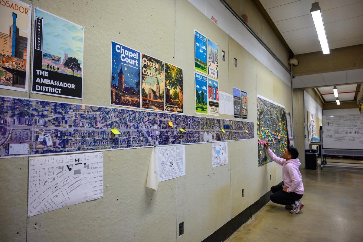 Student working on wall of architectural plans
