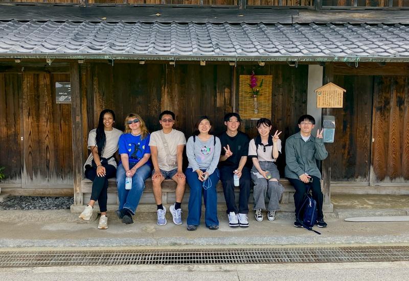 Students sitting on a ledge in Japan